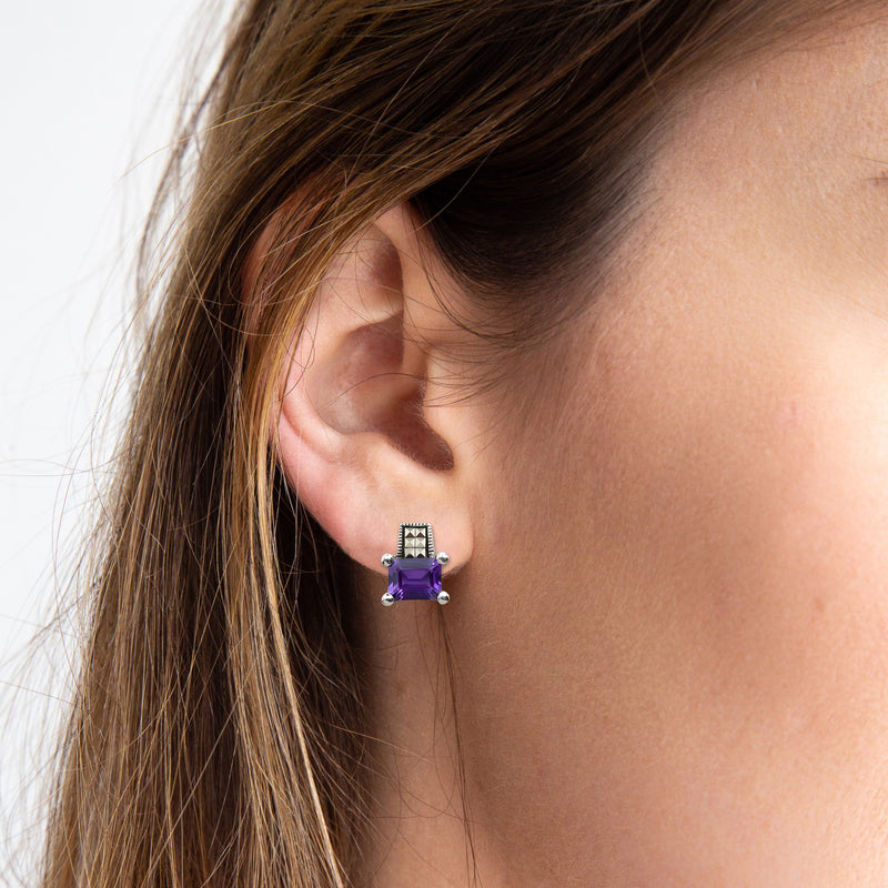 Vintage sterling silver stud earrings set with a single emerald cut amethyst and 6 marcasite (on model)